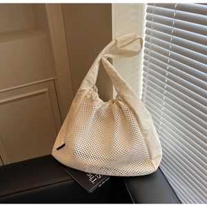 Detail of white mesh tote bag with beige fabric拼接 and drawstring closure mechanism