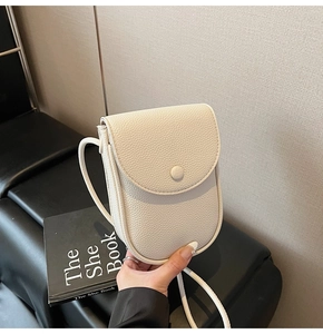 Détail du mini sac de téléphone en cuir grainé blanc cassé avec rabat magnétique chic