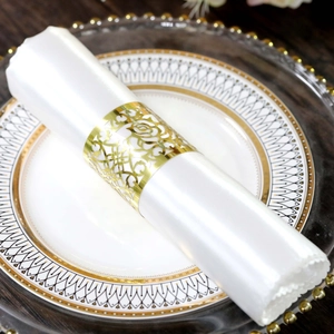 Golden rose hollow metal napkin ring with laser-cut design on elegant white satin napkin