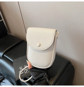 Détail du cuir blanc à grain litchi avec fermeture à rabat et bouton rond magnétique