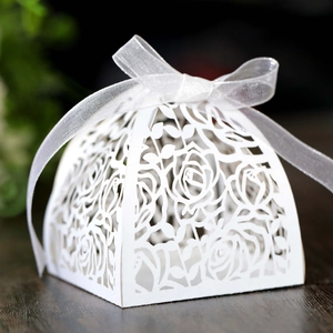 Macro shot of laser-cut rose patterns on white pearlescent paper wedding favor gift box