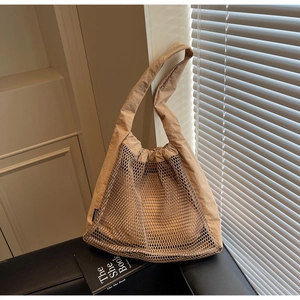 Detail of khaki nylon hollow mesh tote bag with drawstring closure and shoulder strap
