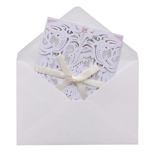 Detailed laser-cut floral wedding invitation with white ribbon and a matching V-flap envelope