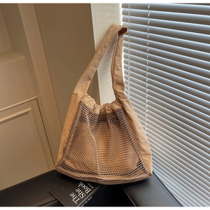 Close-up of khaki hollow nylon mesh tote bag with pleated texture and wide shoulder strap