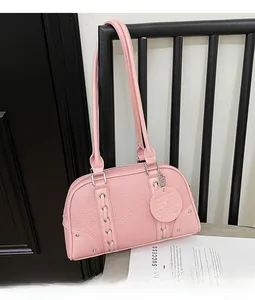 Detail of pink litchi grain boston bag featuring silver metal eyelets and a round tag