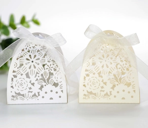 Detail of laser-cut hollow gift boxes with elegant organza ribbons for wedding favors