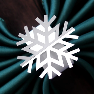 Golden snowflake napkin ring with laser-cut design for Christmas table decoration
