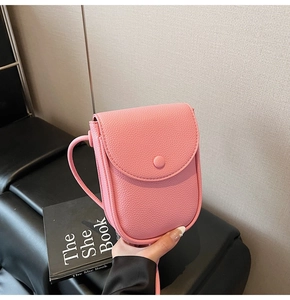 Détail du sac à bandoulière rose en cuir synthétique avec texture grainée lychee