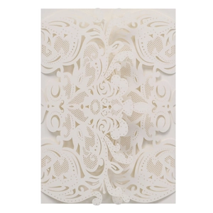 Macro shot of white laser-cut floral filigree details on high-quality wedding invitations