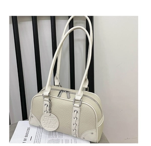 Detail of off-white lychee leather texture with silver studs and dual zipper closure