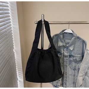 Detail of black mesh tote bag with drawstring closure and wide nylon shoulder strap