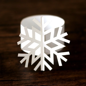 Macro view of white snowflake napkin ring with intricate laser-cut hollow pattern