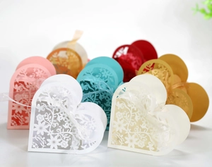 Close-up of laser-cut floral pattern on heart-shaped favor boxes with ribbons