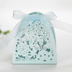 Close-up of light blue laser-cut gift box featuring hollow floral patterns and ribbon