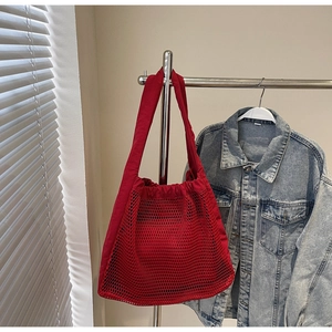 Macro detail of red hollow nylon mesh tote with durable canvas shoulder straps