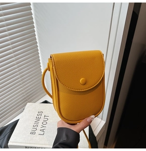 Détail d'un sac de téléphone jaune vif en cuir grainé avec fermeture à rabat