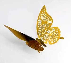 Dettaglio di adesivo murale farfalla 3D oro tagliato al laser con delicati motivi traforati
