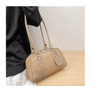 Detail of khaki Boston bag featuring litchi texture, braided decor, and metal zipper on a model