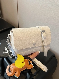 Minimalist beige pebble leather crossbody bag with cute elephant charm and metal strap