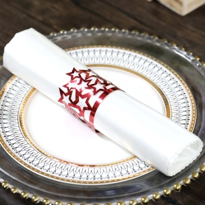 Close-up of red hollowed star napkin ring on a decorative plate for festive events