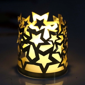Dettaglio dei motivi a stella traforati sul paralume decorativo con luce LED calda