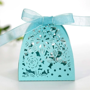 Detail of light blue laser-cut wedding favor box with pearl paper and sheer ribbon bow