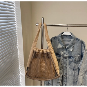 Detail view of khaki hollow nylon mesh tote bag with functional drawstring closure
