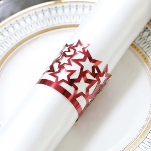 Detailed close-up of red glossy star napkin ring with hollow star pattern on a white napkin