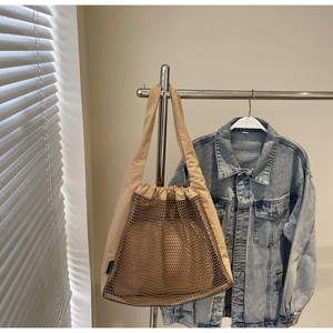 Detailed macro view of khaki mesh tote bag with canvas straps and semi-transparent texture