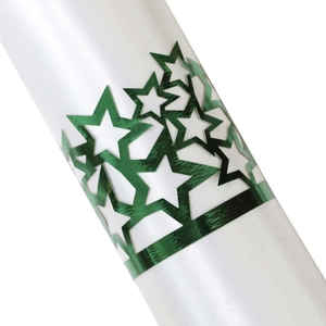 Macro shot of green metallic hollow star napkin ring on white satin fabric texture