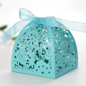Detail of Tiffany blue laser-cut candy box with delicate floral patterns and silk ribbon