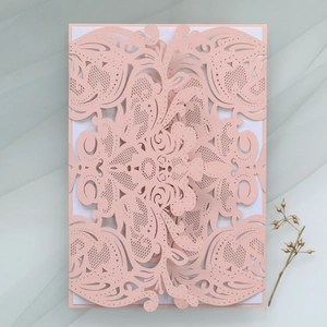 Detailed laser-cut pink wedding invitation with elegant European patterns on soft tulle