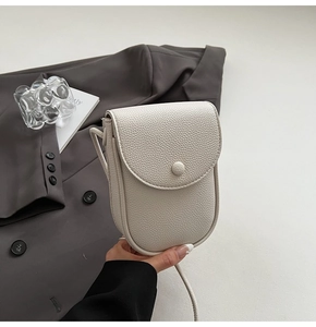 Détail de la texture cuir litchi ivoire et design minimaliste de ce mini sac bandoulière