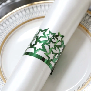 Close-up of green hollow pentagram napkin ring on a white plate for festive tables
