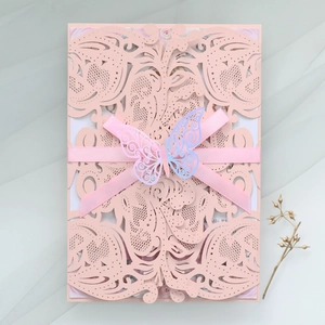 Detail of laser cut wedding invitation with pink ribbon and 3D gradient butterfly
