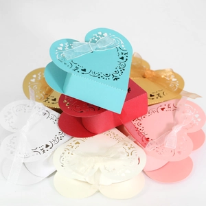 Detail view of colorful laser-cut heart candy boxes with ribbons for wedding gifts