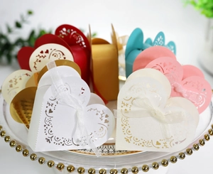 Detail of laser-cut heart pattern gift boxes with silk ribbons for wedding favors