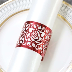 Detail shot of bright red hollow rose napkin ring on white ceramic plate with gold rim