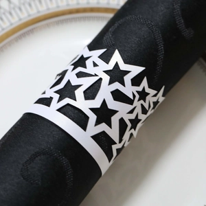 Detail view of laser-cut white paper napkin ring with hollowed star pattern