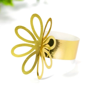 Close-up of golden petal napkin ring with hollow-out flower design for wedding decor