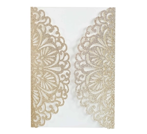 Close-up of laser-cut lace invitation cover with champagne gold glitter finish