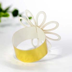 Close-up of elegant gold and white petal napkin ring with intricate cutout flower detail