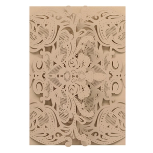 Detailed macro view of laser-cut floral patterns on an elegant champagne wedding invitation