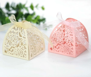 Detailed laser-cut rose hollow candy boxes in pink and beige with sheer ribbon bows
