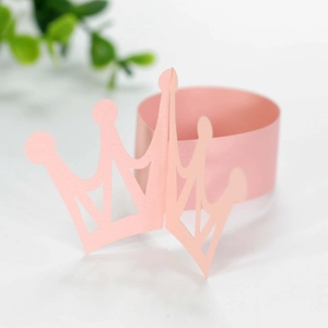 Close-up of pink laser-cut crown cupcake wrappers for party decoration and table setting