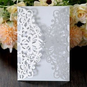 Close-up of laser-cut floral pattern on white pearlescent paper invitation cover
