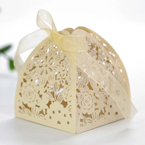 Macro shot of laser-cut gift box with floral rabbit patterns and gold organza ribbon