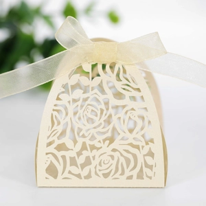 Detailed macro view of laser-cut rose patterns and ribbon on white paper gift box