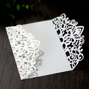 Macro shot of laser-cut floral patterns on a white pearlescent paper wedding invitation