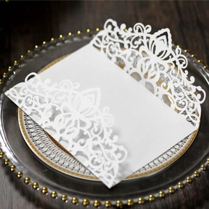 Close-up of laser-cut floral pattern on white pearlescent paper wedding invitation cover
